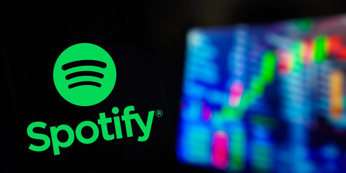 June 3, 2024, Brazil. In this photo illustration, the Spotify logo is displayed on a smartphone screen, with graphic representation of the stock market in the background